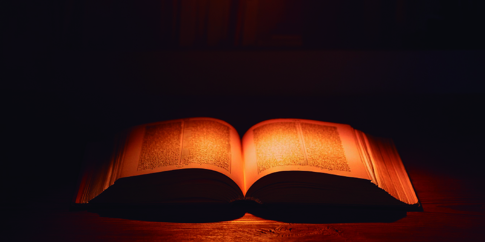 Libro iluminado sobre fondo a oscuras
